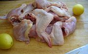 Chicken with lemons on a large wooden cutting board