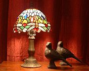 Tiffany dragonfly lamp with pigeon sculptures