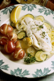 Fish served with vegetables and herbs.
