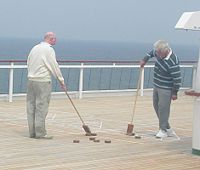 A shuffleboard game being prepared, with shovel-like cues.