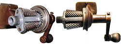 A wall-mounted pencil sharpener (casing removed to reveal the mechanism)