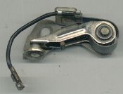 Breaker arm with contact points at the left. The pivot is on the right and the cam follower is in the middle of the breaker arm.